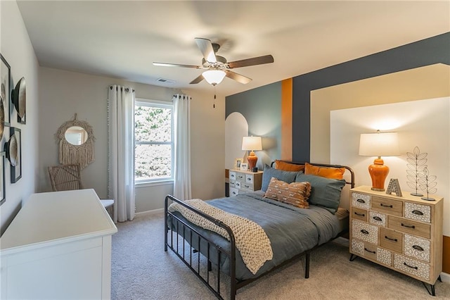 bedroom featuring visible vents, baseboards, a ceiling fan, and light colored carpet