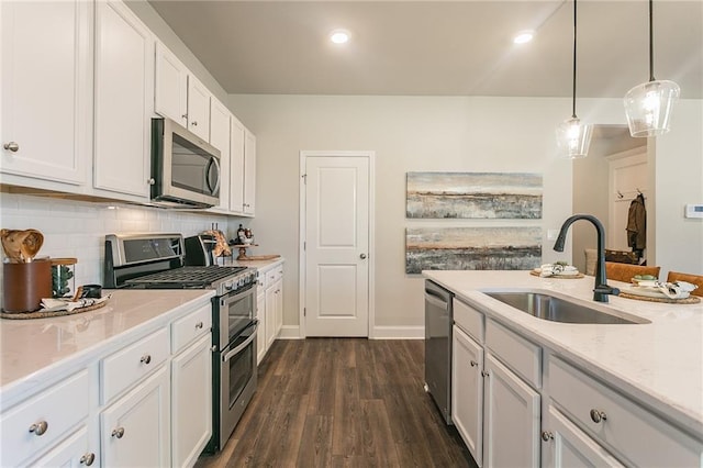 kitchen with tasteful backsplash, appliances with stainless steel finishes, dark wood-type flooring, white cabinetry, and a sink