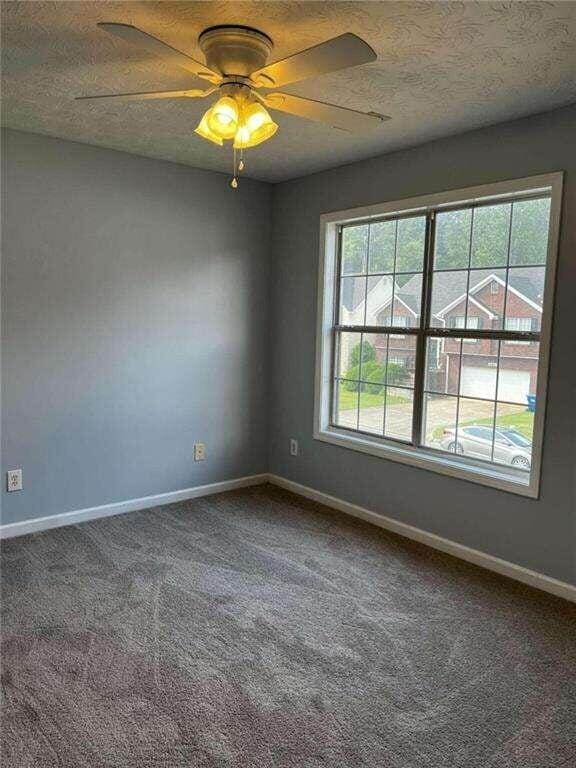 empty room featuring carpet flooring, a textured ceiling, and ceiling fan