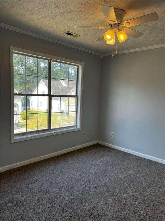 unfurnished room featuring carpet flooring, ceiling fan, and crown molding