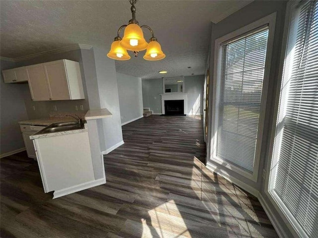 kitchen with white cabinetry, hanging light fixtures, a textured ceiling, and dark hardwood / wood-style floors