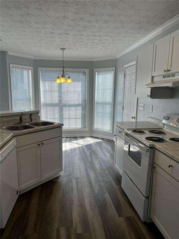 kitchen with white cabinets, white appliances, and pendant lighting