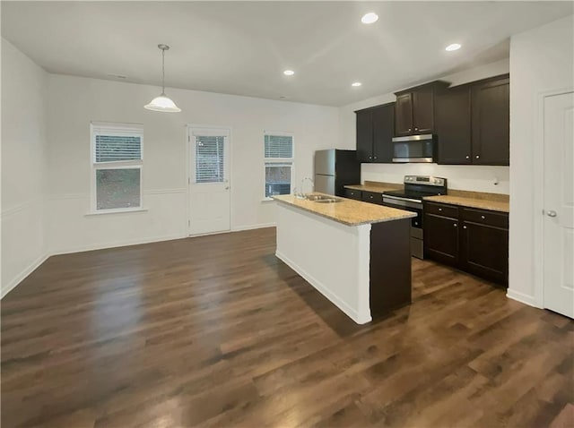 6077 Oakley Rd, Union City, GA 30291 - kitchen featuring hanging light fixtures, a center island with sink, appliances with stainless steel finishes, dark hardwood / wood-style floors, and light stone countertops