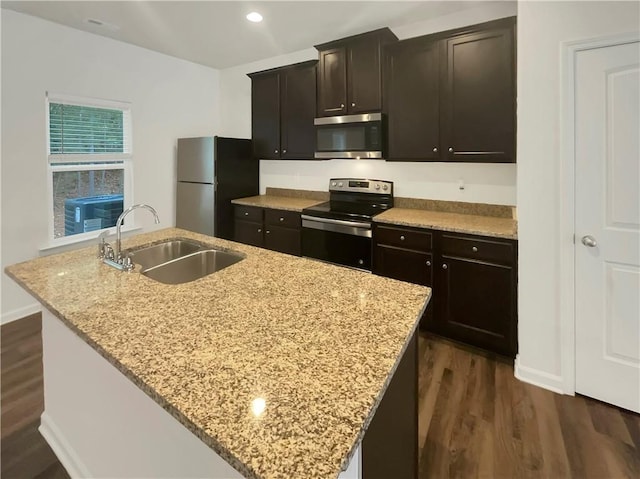 6077 Oakley Rd, Union City, GA 30291 - kitchen featuring appliances with stainless steel finishes, sink, a center island with sink, and light stone counters