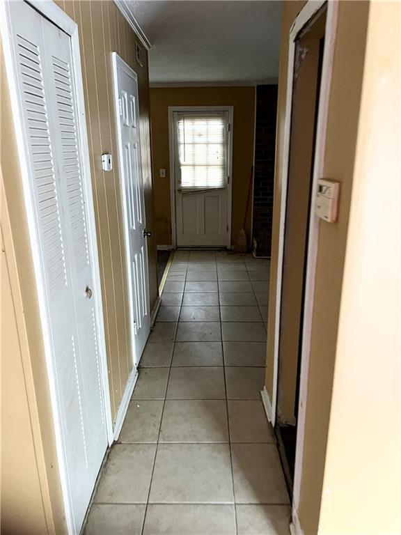 6354 Shannon Pkwy Unit 30D, Union City, GA 30291 - corridor featuring wooden walls, ornamental molding, and light tile patterned flooring