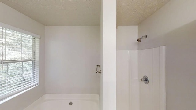 488 Barclay Ct, Stone Mountain, GA 30083 - bathroom with a textured ceiling, a bath, and a shower