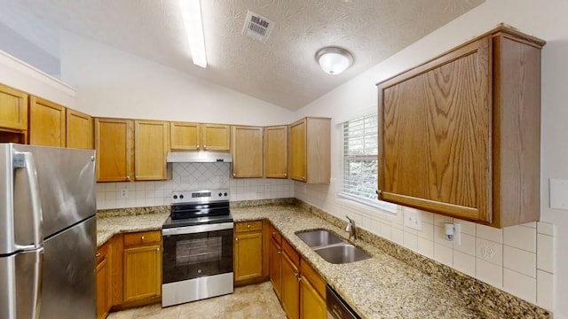 488 Barclay Ct, Stone Mountain, GA 30083 - kitchen with stainless steel appliances, under cabinet range hood, vaulted ceiling, light stone counters, and tasteful backsplash