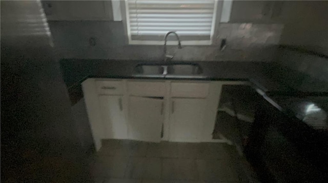 kitchen featuring white cabinetry and sink