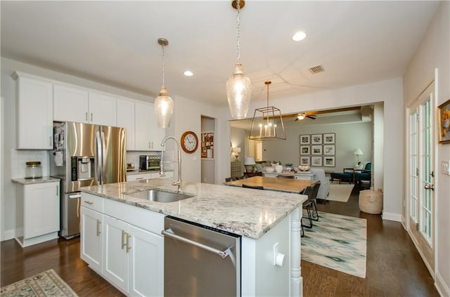 2535 Castlerock Ct, Cumming, GA 30041 - kitchen featuring stainless steel appliances, dark wood-style flooring, open floor plan, white cabinetry, and pendant lighting