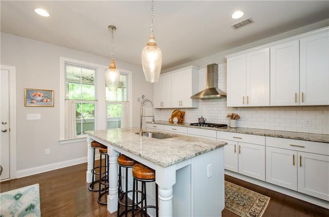 2535 Castlerock Ct, Cumming, GA 30041 - kitchen with wall chimney exhaust hood, tasteful backsplash, a kitchen island with sink, dark wood-type flooring, and a kitchen breakfast bar