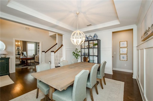 2535 Castlerock Ct, Cumming, GA 30041 - dining area with a chandelier, a raised ceiling, dark wood-style floors, crown molding, and stairway