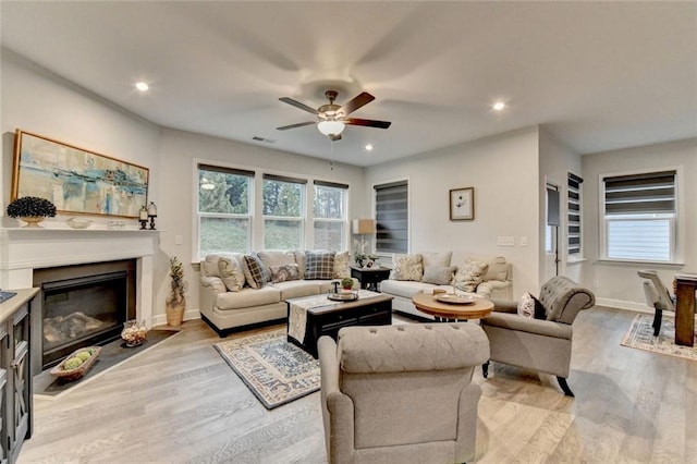 living room featuring light wood-type flooring, plenty of natural light, visible vents, and recessed lighting