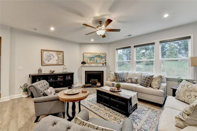 living area with a fireplace, wood finished floors, visible vents, and recessed lighting