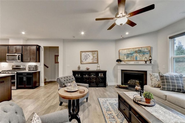 living area featuring light wood finished floors, a fireplace, and recessed lighting