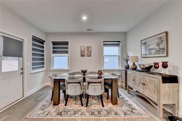 dining room with light wood-style floors, baseboards, and visible vents