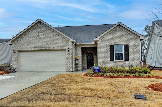 ranch-style home featuring roof with shingles, driveway, brick siding, and an attached garage