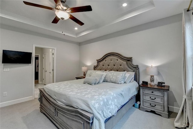 bedroom with recessed lighting, light carpet, a ceiling fan, baseboards, and a tray ceiling