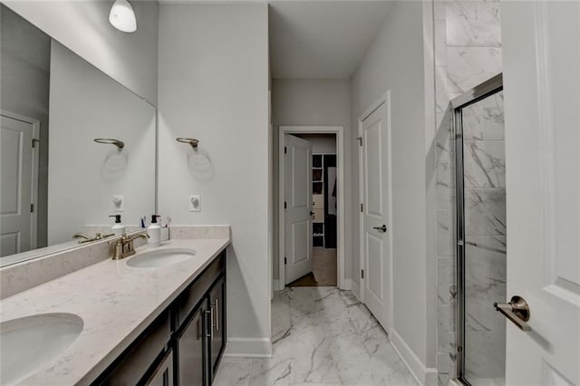 bathroom with marble finish floor, a shower stall, baseboards, and a sink