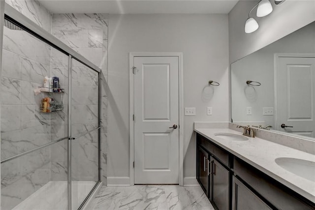 full bath with double vanity, a stall shower, baseboards, marble finish floor, and a sink