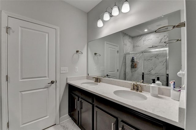 bathroom with double vanity, a marble finish shower, a sink, and marble finish floor