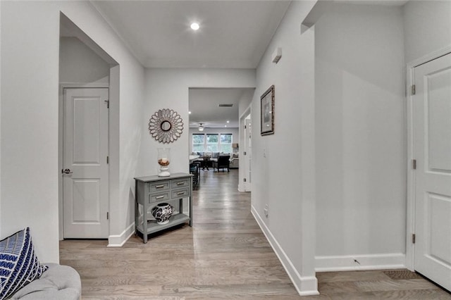 hallway with recessed lighting, light wood-style flooring, and baseboards