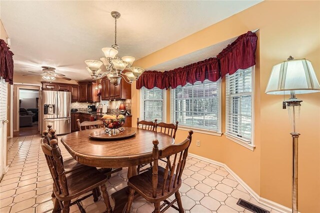 dining room featuring ceiling fan with notable chandelier