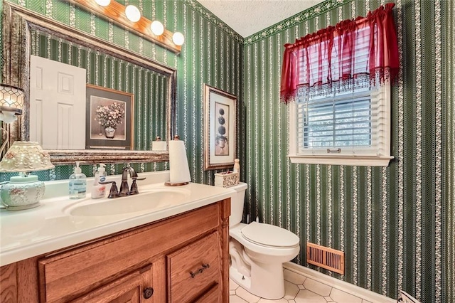 bathroom with tile patterned flooring, vanity, a textured ceiling, and toilet