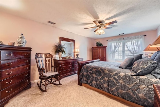 carpeted bedroom featuring a textured ceiling and ceiling fan