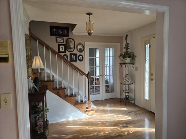 foyer entrance with hardwood / wood-style floors and ornamental molding