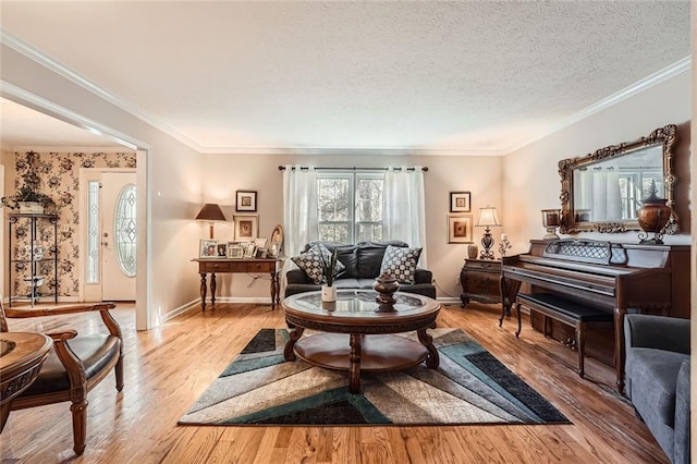 sitting room with a textured ceiling, light hardwood / wood-style flooring, and crown molding