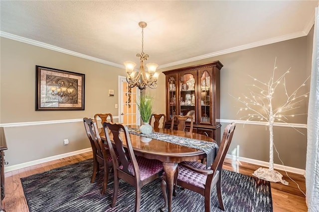 dining space featuring a chandelier, ornamental molding, and hardwood / wood-style flooring