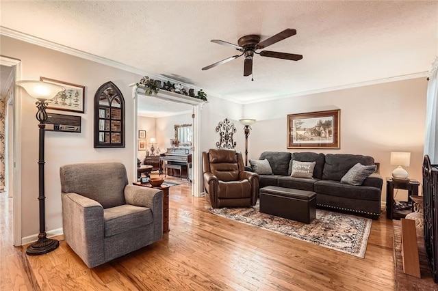 living room with hardwood / wood-style floors, ceiling fan, crown molding, and a textured ceiling