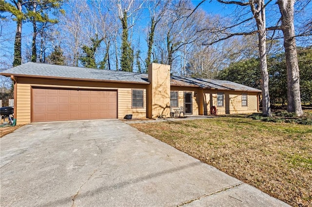 ranch-style house featuring a garage and a front lawn