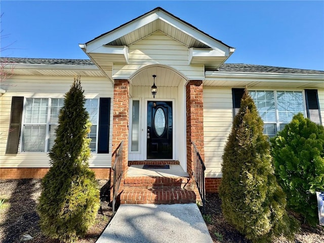 doorway to property with a shingled roof