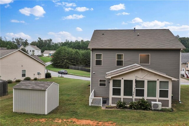 back of house featuring a lawn, ac unit, and a storage shed