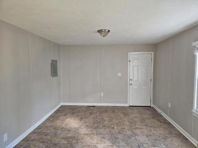 unfurnished room featuring a textured ceiling