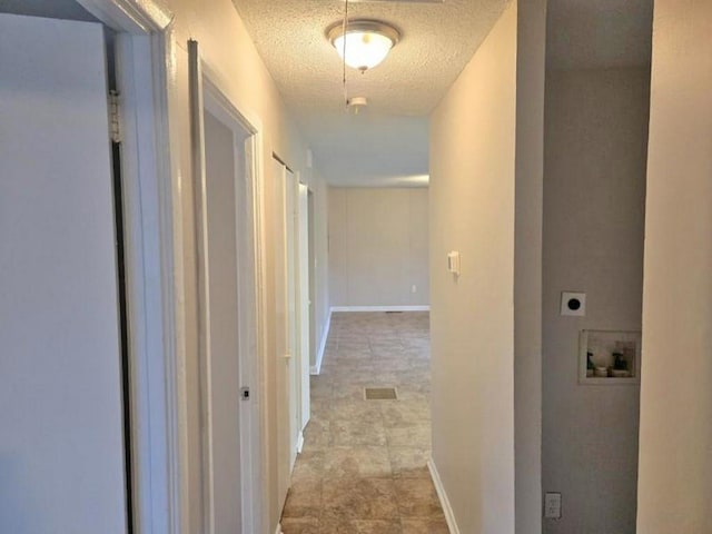 hallway with a textured ceiling