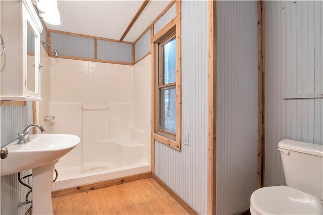 bathroom with a shower, toilet, sink, and hardwood / wood-style floors