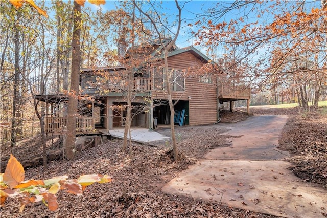 view of side of property with a wooden deck and a patio area