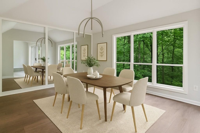 dining space featuring vaulted ceiling, dark wood-type flooring, and baseboards