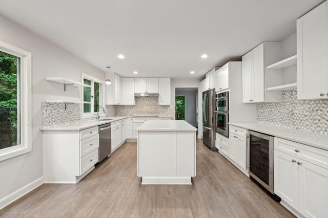 kitchen with open shelves, appliances with stainless steel finishes, wine cooler, backsplash, and a center island
