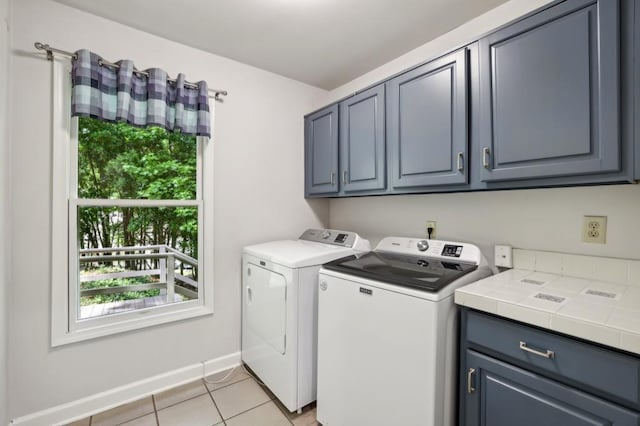 laundry area featuring cabinet space, washing machine and dryer, plenty of natural light, and light tile patterned floors