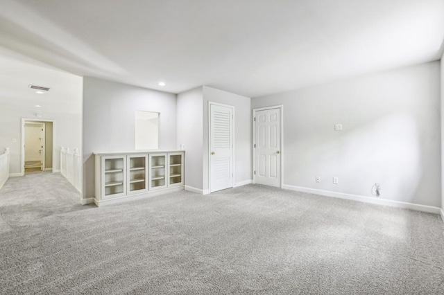 empty room featuring carpet, baseboards, and recessed lighting