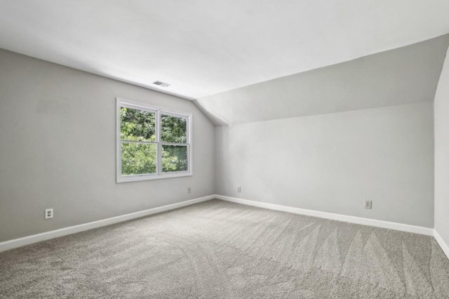 additional living space with baseboards, vaulted ceiling, and carpet floors