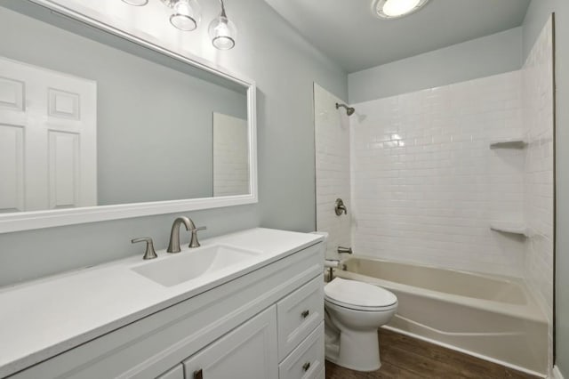 full bath with wood finished floors, toilet, vanity, and shower / bath combination