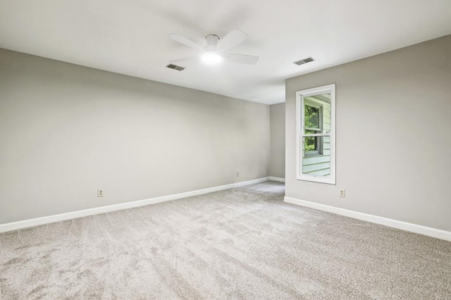 carpeted empty room with ceiling fan and baseboards