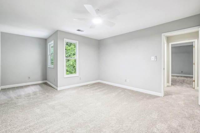 unfurnished room featuring baseboards, a ceiling fan, and light colored carpet