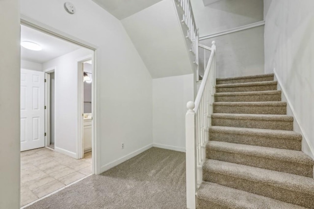 stairs with carpet, baseboards, and tile patterned flooring