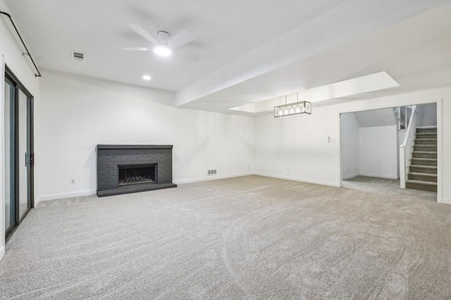 unfurnished living room featuring carpet flooring, stairway, a ceiling fan, and baseboards