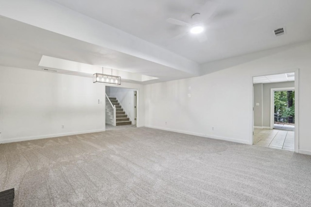 unfurnished room featuring carpet, a ceiling fan, stairs, and baseboards